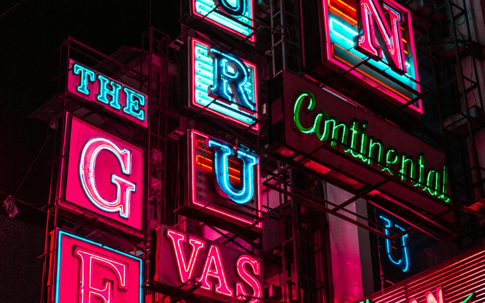 Wall of vibrant illuminated LED channel-letter signs at night